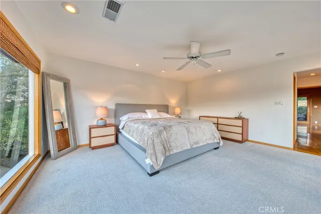 a spacious bedroom with a bed and large windows