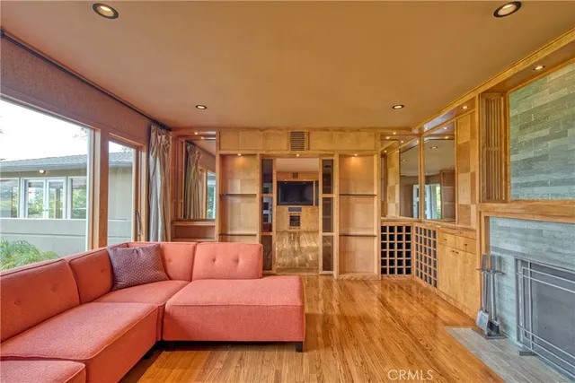 a living room with furniture a large window and wooden floor