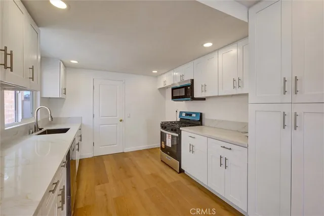 a kitchen with stainless steel appliances granite countertop a sink stove and refrigerator