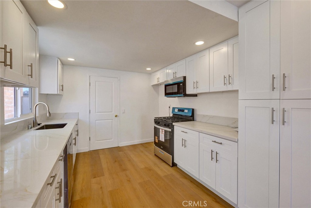 1807 East Calstock Street Carson, CA 90746 - Photo 3 of 11 a kitchen with stainless steel appliances granite countertop a sink stove and refrigerator
