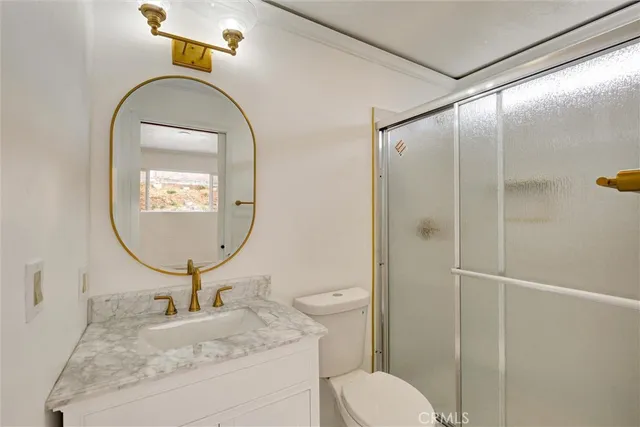 a bathroom with a granite countertop sink mirror and toilet