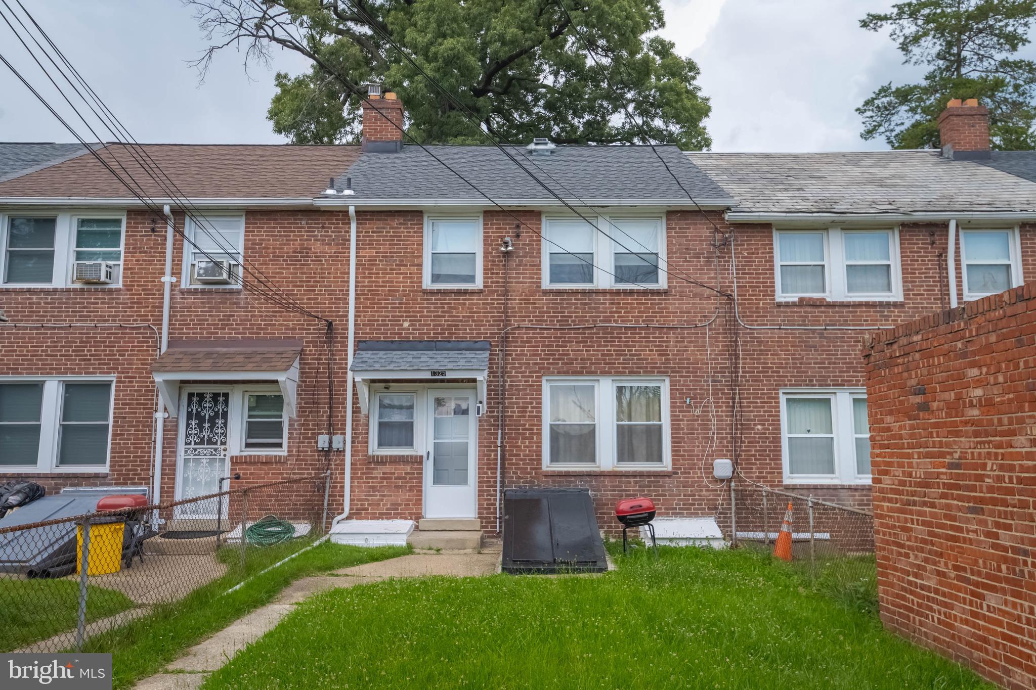 1325 Crofton Road Baltimore, MD 21239 - Photo 22 of 25 a front view of a house with a yard and green space