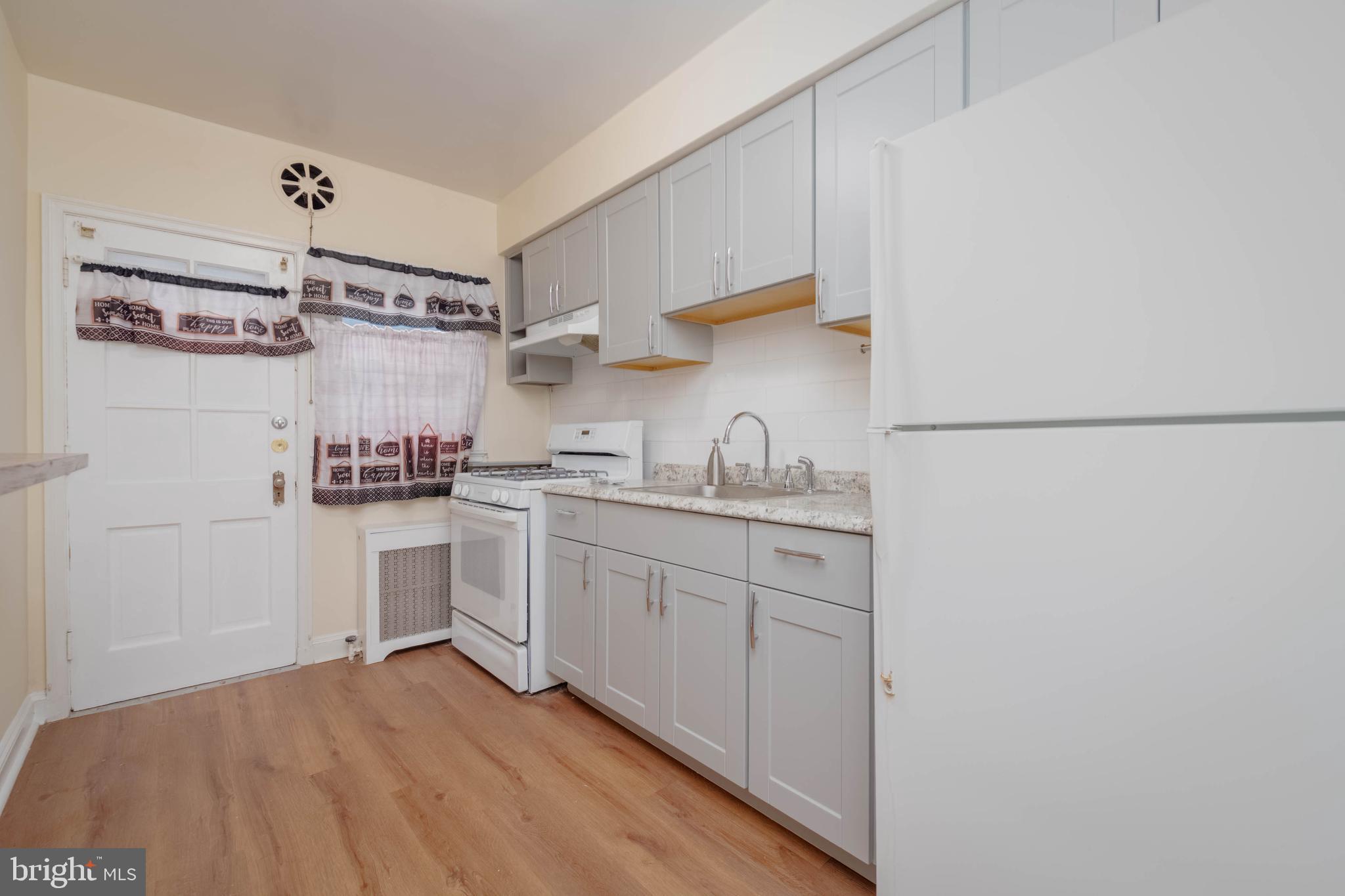 1325 Crofton Road Baltimore, MD 21239 - Photo 6 of 25 a kitchen with cabinets and white appliances