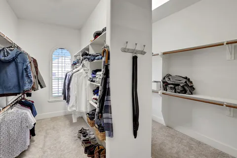 a view of walk in closet with clothes and shoes