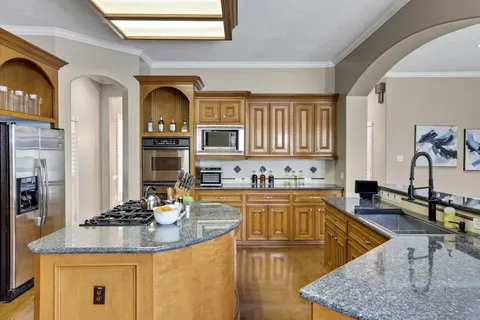 a kitchen with stainless steel appliances granite countertop a sink and cabinets