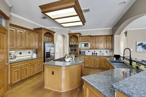a kitchen with stainless steel appliances granite countertop a stove a sink dishwasher and cabinets with wooden floor