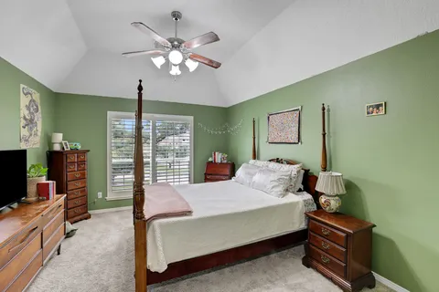a bedroom with a bed and a flat tv screen on dresser