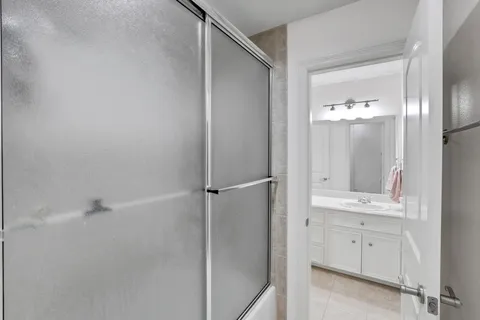 a bathroom with a shower sink and mirror