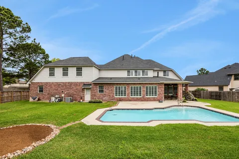 a view of a house with a swimming pool and yard