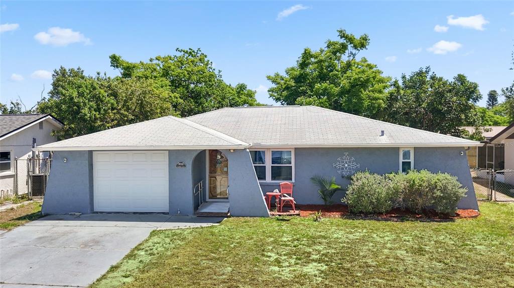 8840 Carmen Lane Port Richey, FL 34668 - Photo 1 of 49 a backyard of a house with yard and outdoor seating