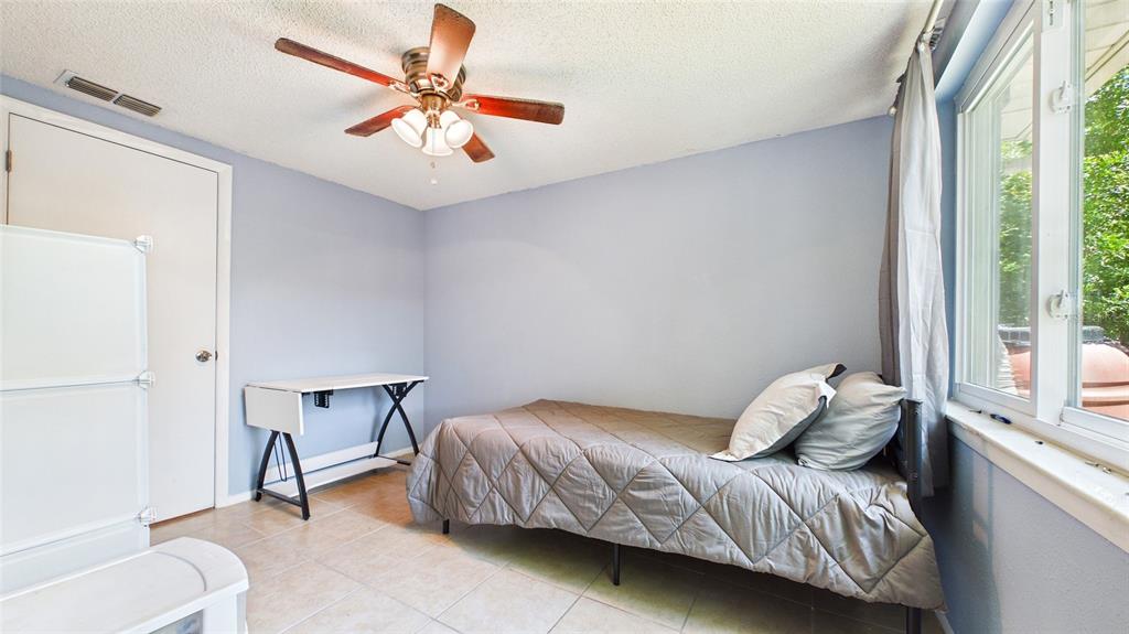 8840 Carmen Lane Port Richey, FL 34668 - Photo 20 of 49 a bedroom with a bed and a chair