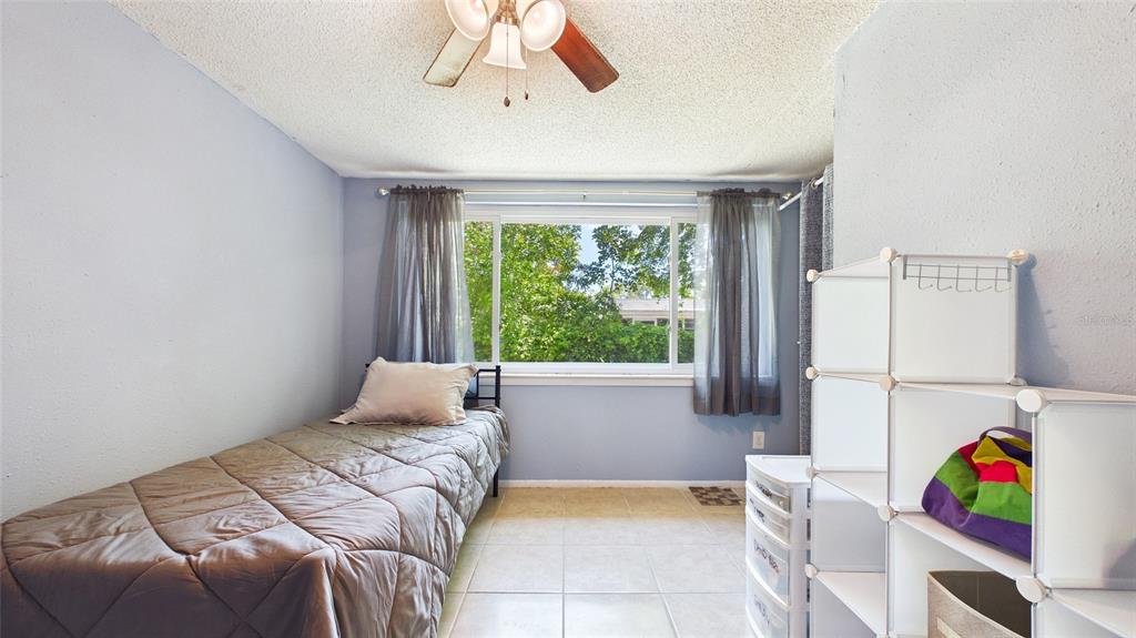 8840 Carmen Lane Port Richey, FL 34668 - Photo 21 of 49 a bedroom with a bed a couch and a window