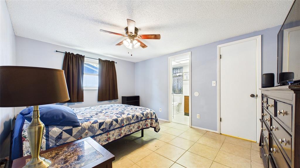 8840 Carmen Lane Port Richey, FL 34668 - Photo 24 of 49 a bedroom with a bed and a chandelier