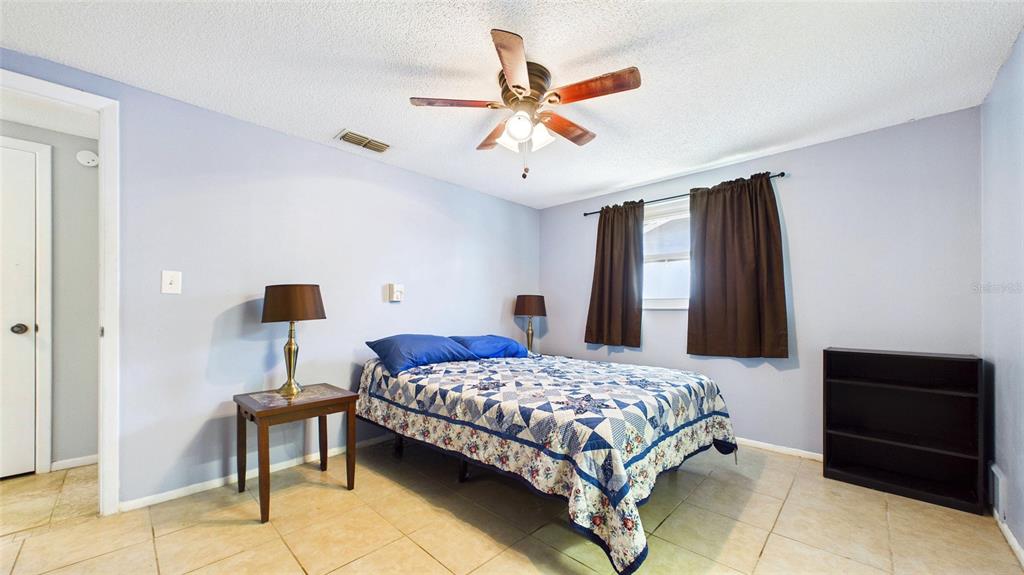 8840 Carmen Lane Port Richey, FL 34668 - Photo 25 of 49 a bedroom with a bed and a ceiling fan