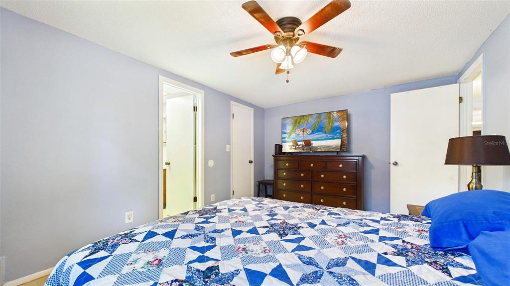 8840 Carmen Lane Port Richey, FL 34668 - Photo 26 of 49 a bedroom with a bed and a lamp on dresser