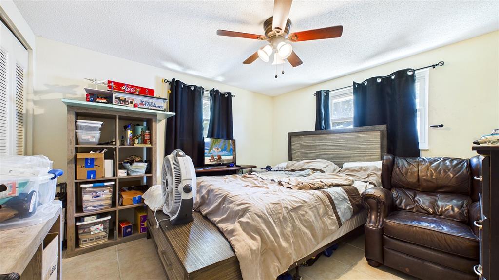 8840 Carmen Lane Port Richey, FL 34668 - Photo 32 of 49 a bedroom with a bed and a chandelier