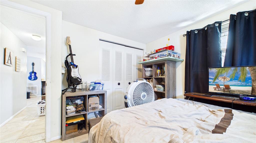 8840 Carmen Lane Port Richey, FL 34668 - Photo 33 of 49 a bedroom with a bed and a flat screen tv