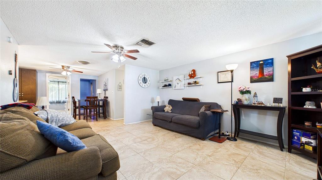 8840 Carmen Lane Port Richey, FL 34668 - Photo 4 of 49 a living room with furniture and a flat screen tv