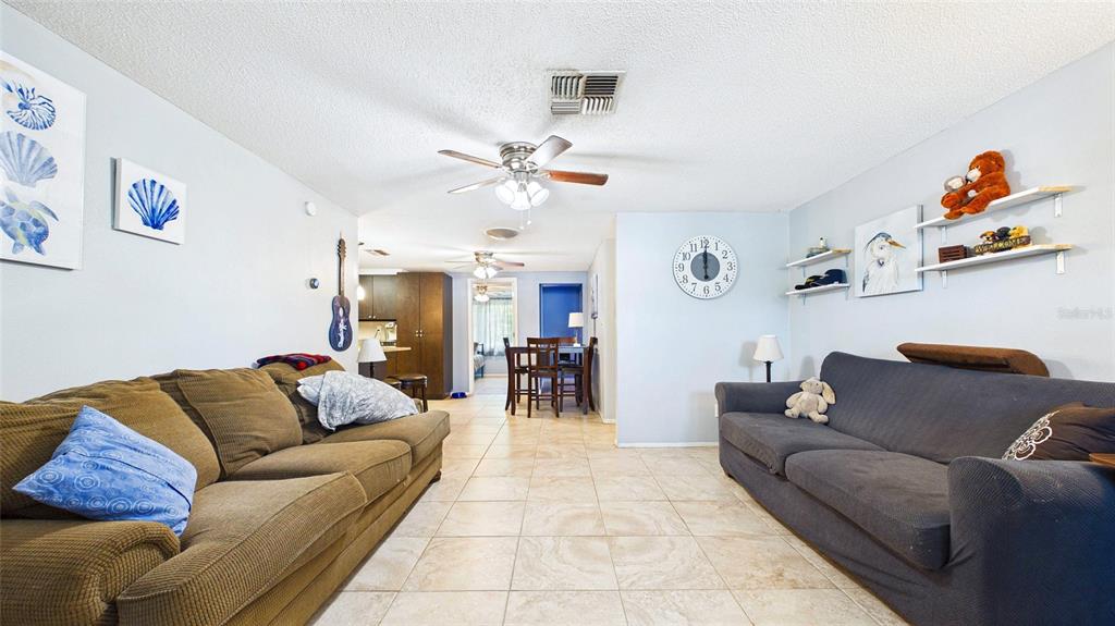 8840 Carmen Lane Port Richey, FL 34668 - Photo 8 of 49 a living room with furniture and a chandelier