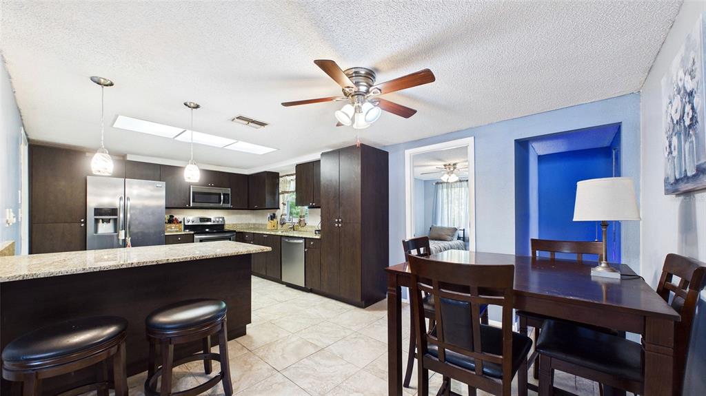 8840 Carmen Lane Port Richey, FL 34668 - Photo 9 of 49 a kitchen with a dining table chairs and refrigerator