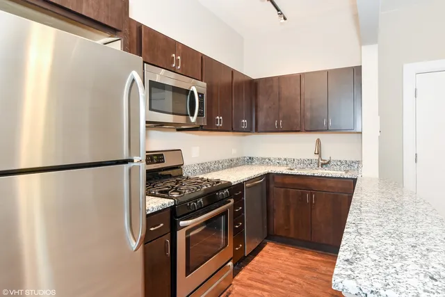 a kitchen with stainless steel appliances granite countertop a refrigerator stove and microwave