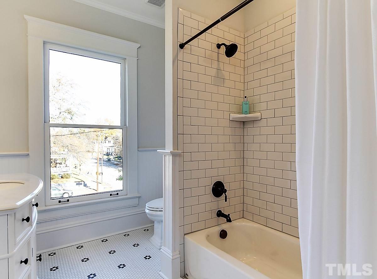414 New Bern Avenue Raleigh, NC 27601 - Photo 22 of 24 a bathroom with a bathtub a window and a shower