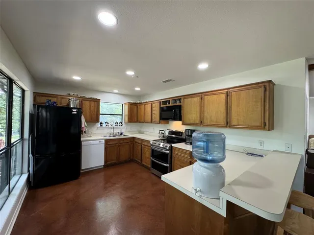 a kitchen with stainless steel appliances granite countertop a refrigerator stove top oven a sink and dishwasher