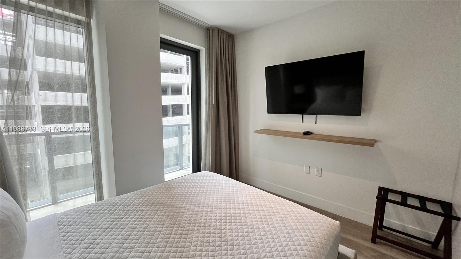 229 Southwest 9th Street, Unit 307 Miami, FL 33130 - Photo 12 of 36 a bedroom with a bed and a flat screen tv