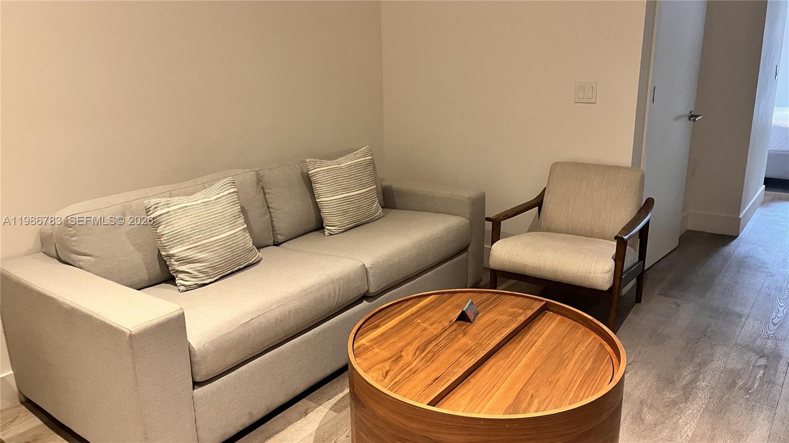 229 Southwest 9th Street, Unit 307 Miami, FL 33130 - Photo 3 of 36 a living room with a couch and a wooden floor