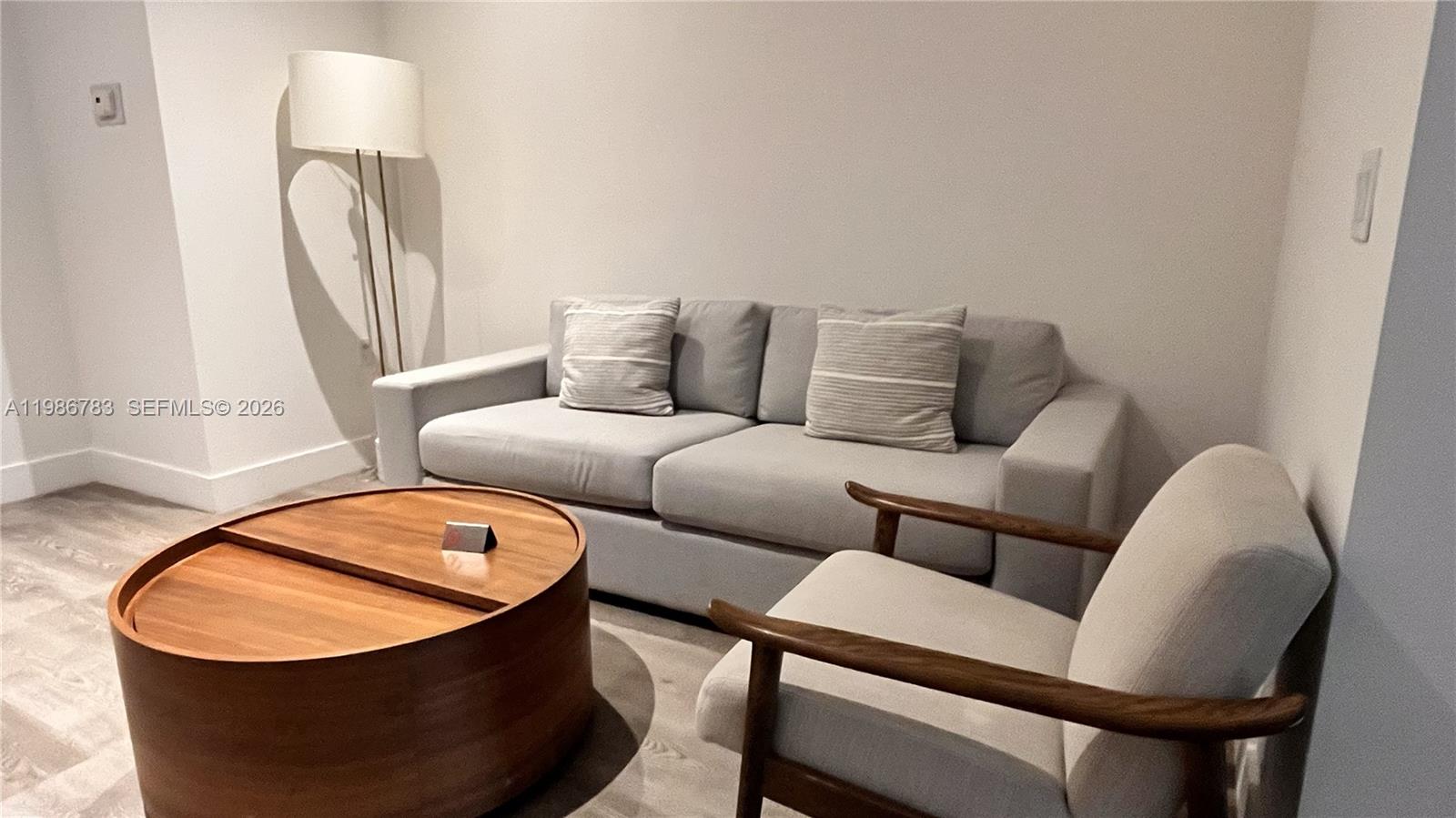 229 Southwest 9th Street, Unit 307 Miami, FL 33130 - Photo 4 of 36 a living room with furniture a mirror and a wooden floor