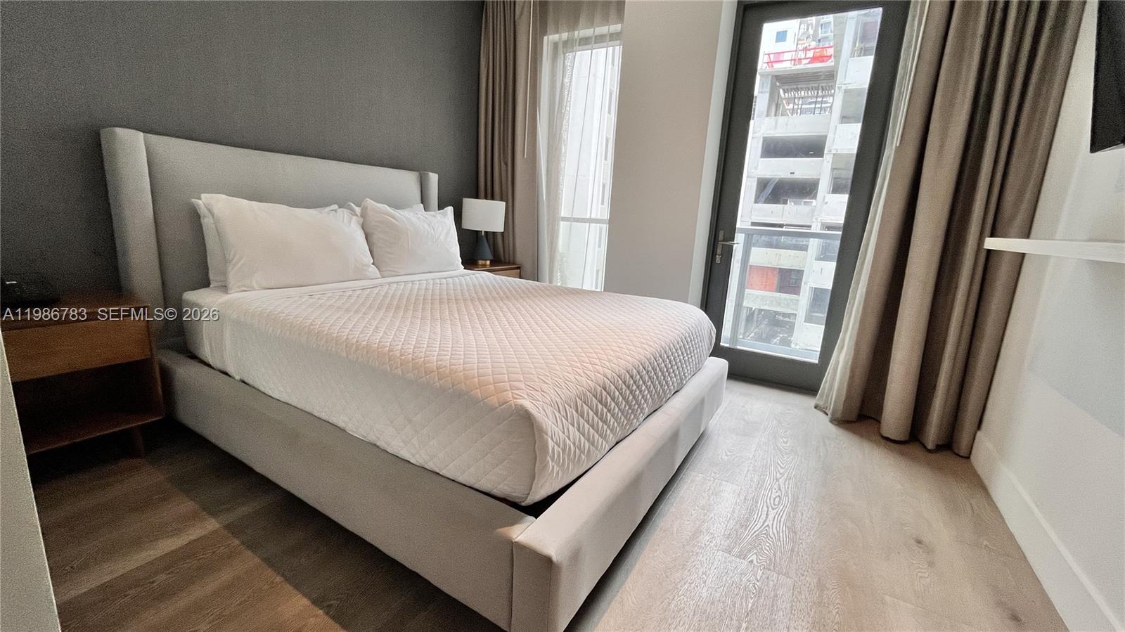 229 Southwest 9th Street, Unit 307 Miami, FL 33130 - Photo 9 of 36 a large bed sitting in a bedroom next to a window