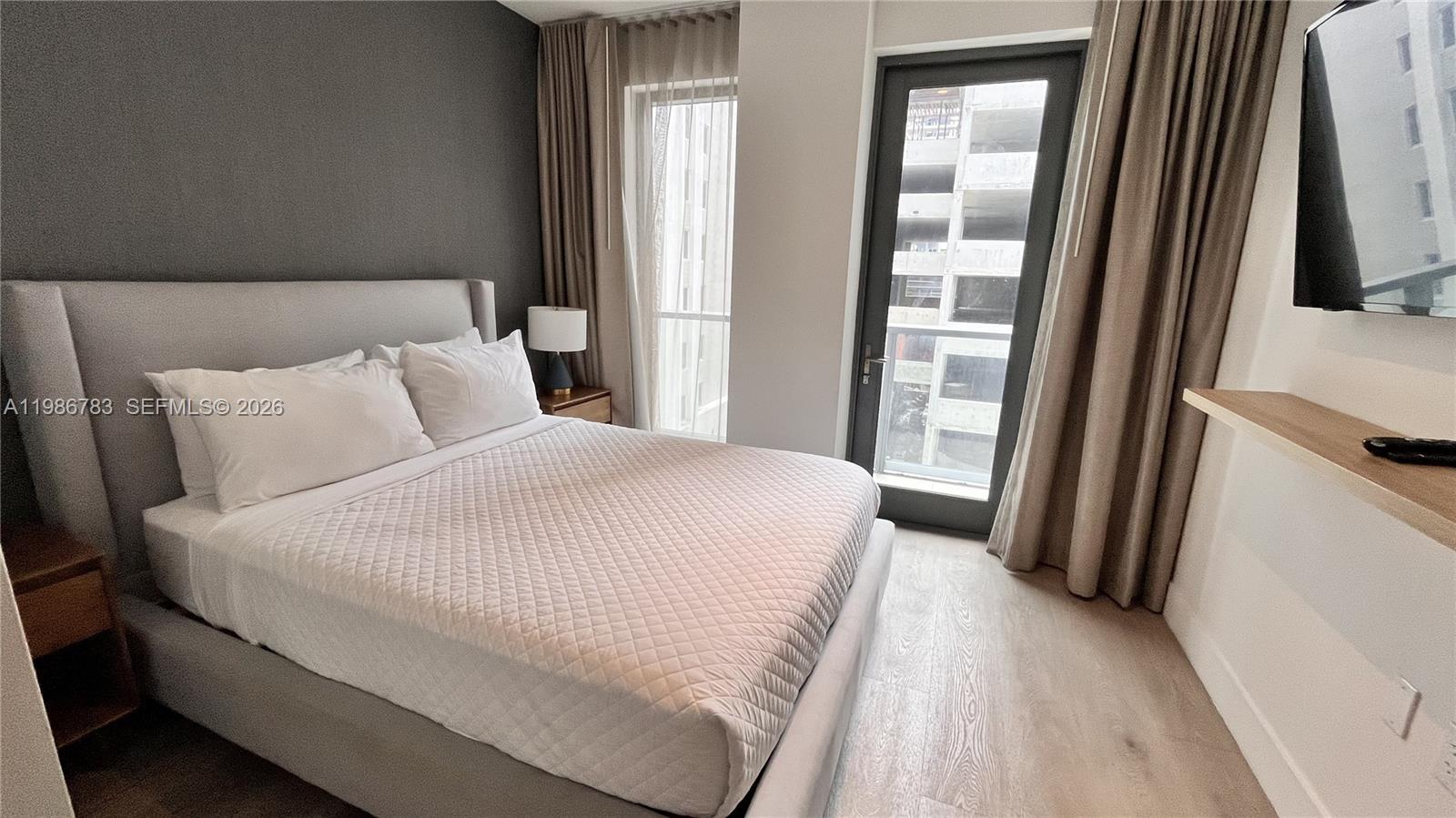 229 Southwest 9th Street, Unit 307 Miami, FL 33130 - Photo 10 of 36 a bedroom with a bed and a large mirror