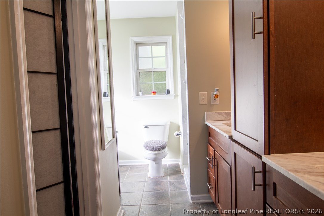 1629 Mattie Road Sanford, NC 27332 - Photo 11 of 29 a bathroom with a granite countertop sink and a toilet