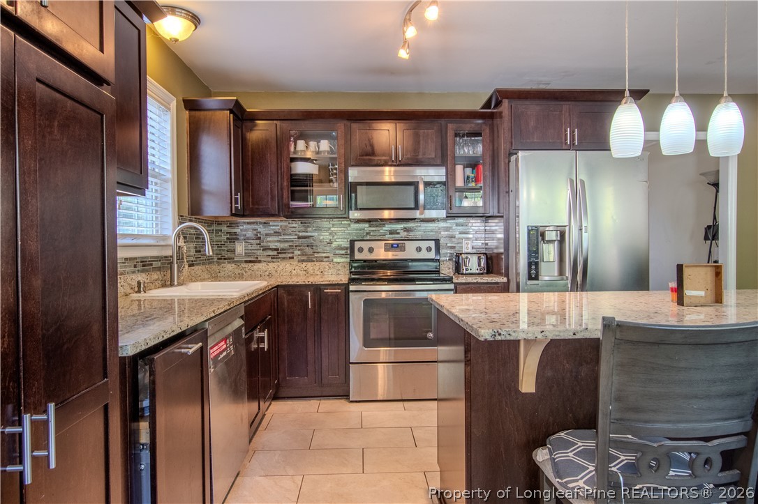 1629 Mattie Road Sanford, NC 27332 - Photo 8 of 29 a kitchen with stainless steel appliances granite countertop a sink stove and refrigerator