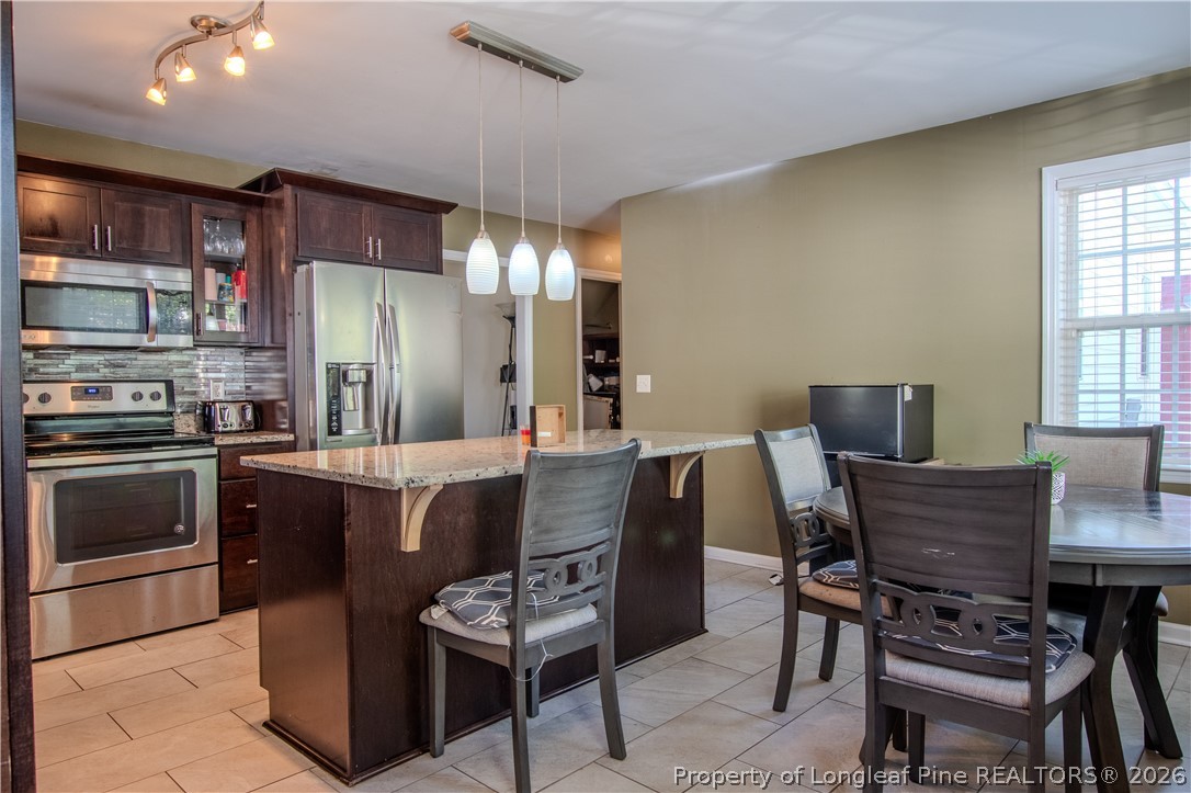 1629 Mattie Road Sanford, NC 27332 - Photo 9 of 29 a kitchen with a dining table chairs and refrigerator