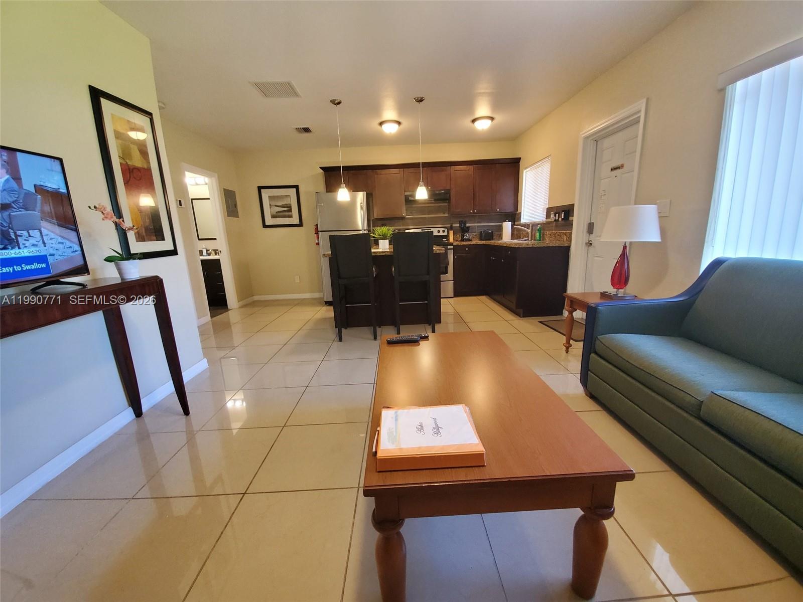 2015 Funston Street, Unit 2 Hollywood, FL 33020 - Photo 15 of 19 a living room with furniture and a flat screen tv