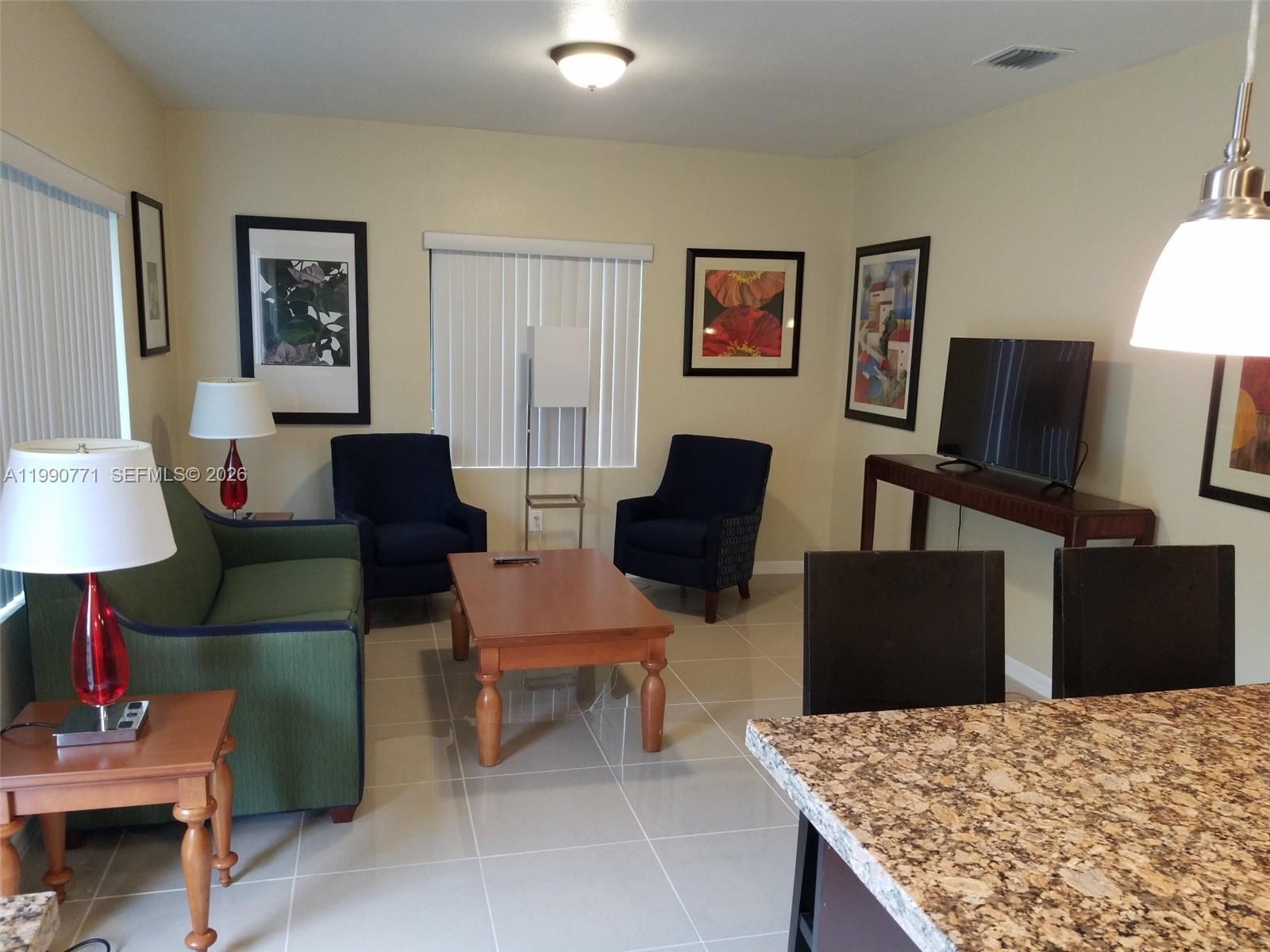 2015 Funston Street, Unit 2 Hollywood, FL 33020 - Photo 7 of 19 a living room with furniture a lamp and a flat screen tv