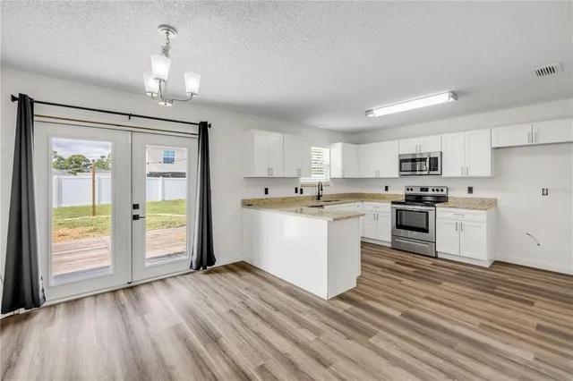 a kitchen with white cabinets and stainless steel appliances