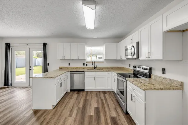 a kitchen with granite countertop appliances cabinets and a sink