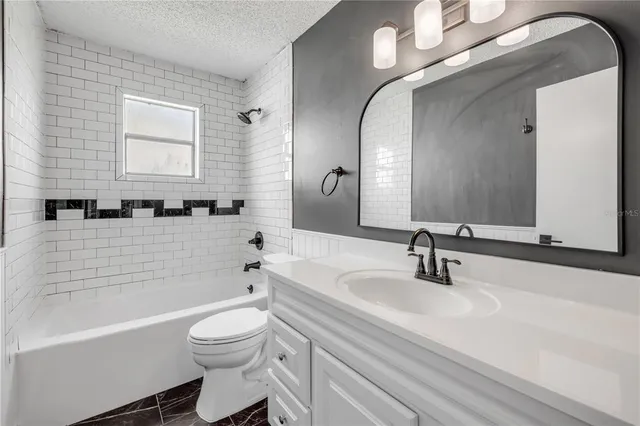 a bathroom with a toilet a sink a mirror and bathtub