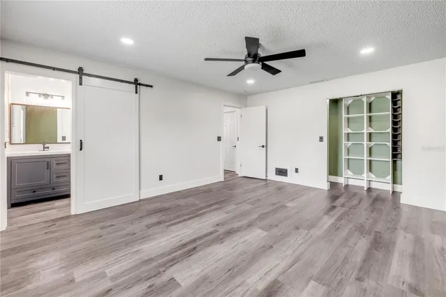 a view of a livingroom with a ceiling fan wooden floor and a ceiling fan