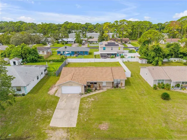 an aerial view of residential houses with outdoor space and swimming pool