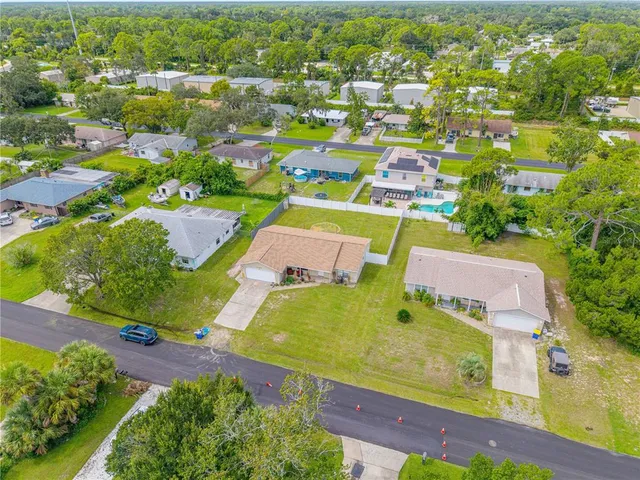 an aerial view of residential houses with outdoor space and parking