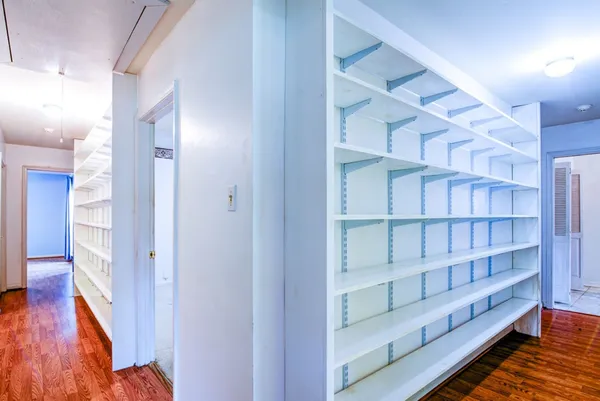 a view of a hallway with wooden floor and closet