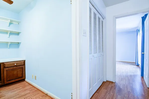 an empty room with closet and a chandelier fan