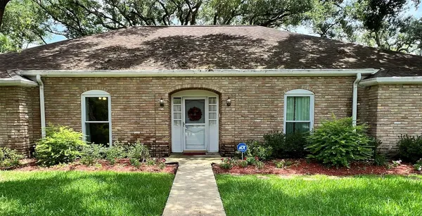 a front view of a house with a yard and trees