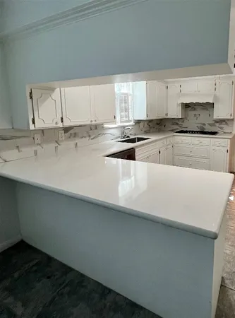 a kitchen with stainless steel appliances a sink dishwasher a stove and white cabinets