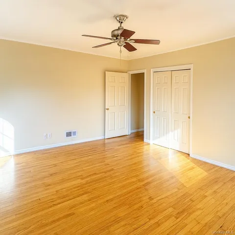 a view of empty room with wooden floor
