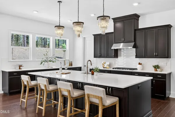 a kitchen with a dining table chairs sink and cabinets
