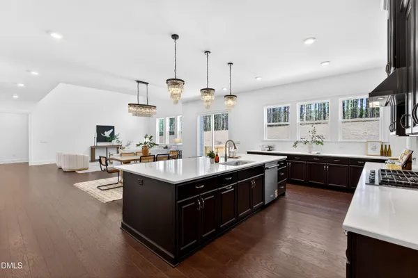 a kitchen with stainless steel appliances granite countertop a sink a stove and a wooden floors